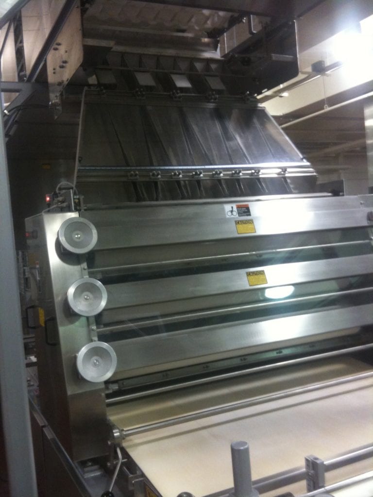 Stainless steel bakery equipment with roller assembly, viewed from the floor