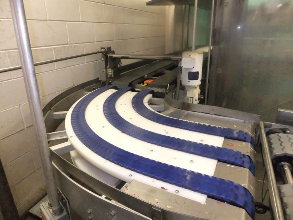 Curved belt conveyor turning through ninety degrees in a bakery plant